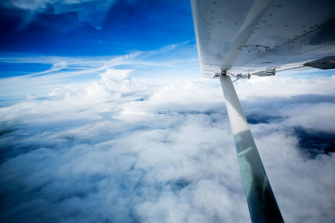 Picture taken during a flight above blue skies with some clouds